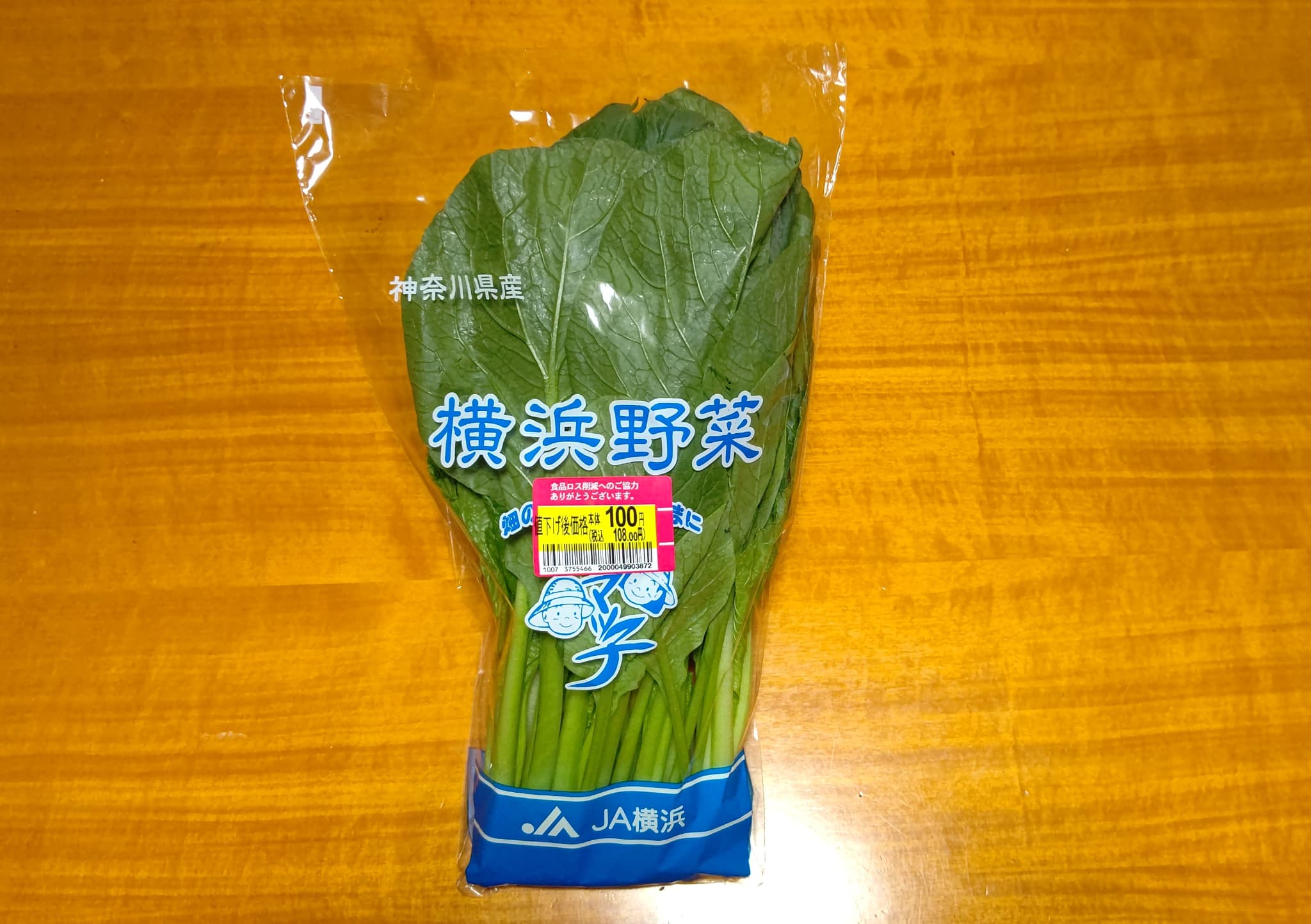 イオン駒岡店で売られていた横浜野菜の小松菜。割引後税抜き１００円のシールが貼られている